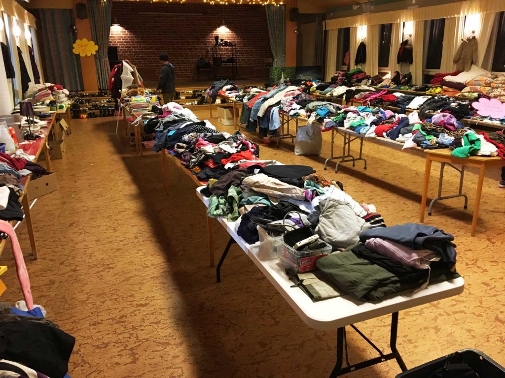 Bild på borden som är fulla av kläder i gamla matsalen i Fellingsbro inför loppiset
