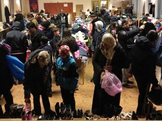 Bild på en fullsatt matsal med människor som letar fynd på loppiset