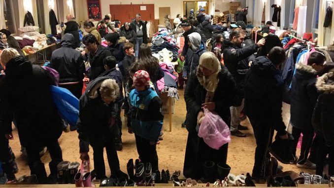 Bild på en fullsatt matsal med människor som letar fynd på loppiset